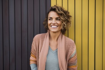 Portrait of a Brazilian woman in her 40s in an abstract background wearing a chic cardigan