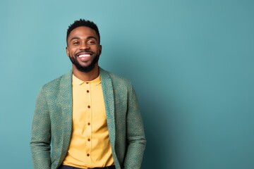 Medium shot portrait of a Nigerian man in his 30s in an abstract background wearing a chic cardigan