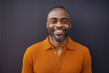 Fototapeta premium Portrait of a Nigerian man in his 40s in an abstract background wearing a chic cardigan