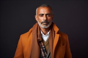 Obraz premium Portrait of a Saudi Arabian man in his 50s in an abstract background wearing a chic cardigan