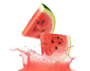 Cut watermelon falling into juice on white background