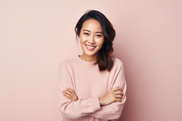 Fototapeta premium Portrait of a Chinese woman in her 30s in a pastel or soft colors background wearing a cozy sweater