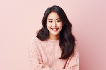 Portrait of a Chinese woman in her 30s in a pastel or soft colors background wearing a cozy sweater