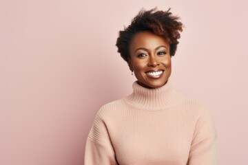 Fototapeta premium Portrait of a Nigerian woman in her 40s in a pastel or soft colors background wearing a cozy sweater