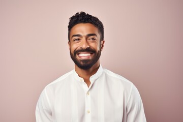 Obraz premium Portrait of a Saudi Arabian man in his 30s in a pastel or soft colors background wearing a chic cardigan
