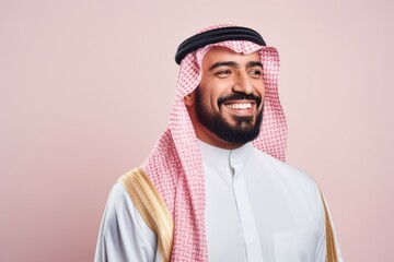 Fototapeta premium Portrait of a Saudi Arabian man in his 30s in a pastel or soft colors background wearing a chic cardigan