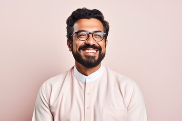 Obraz premium Portrait of a Saudi Arabian man in his 30s in a pastel or soft colors background wearing a chic cardigan