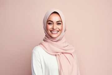Medium shot portrait of a Saudi Arabian woman in her 40s in a pastel or soft colors background wearing a chic cardigan