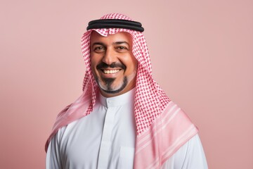 Fototapeta premium Portrait of a Saudi Arabian man in his 40s in a pastel or soft colors background wearing a foulard