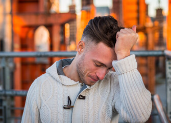 Photo of a man in distress, holding his head