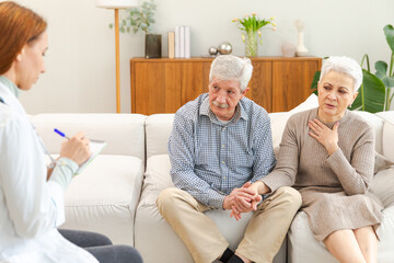 Female doctor examining older senior couple in doctor office or at home. Old woman man patient and...
