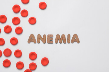 Red blood cells model and word anemia on white background. Medicine and healthcare