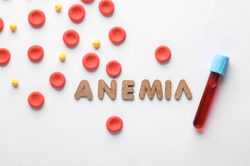 Red blood cells model and word anemia, test tube on white background. Medicine and healthcare