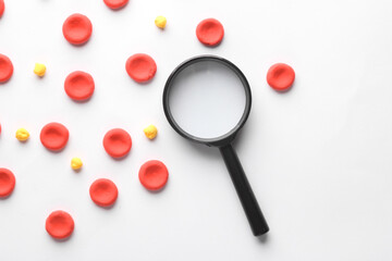 Red blood cells with lipids model  and magnifying glass on white background. Cholesterol
