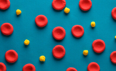 Red blood cells with lipids model made from plasticine on blue background. Cholesterol