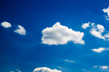 Naklejka na ściany i meble White clouds in deep blue summer sky