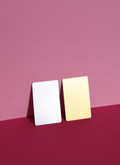 Metallic and golden business cards on pink background with shadow. Creative layout, minimalism