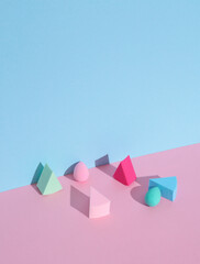 Makeup sponges blenders on a pink blue background with shadow. Beauty concept. Creative layout, minimalism