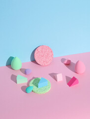 Makeup sponges blenders on a pink blue background with shadow. Beauty concept. Creative layout, minimalism