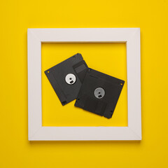 Retro floppy disks in white frame on yellow background. Creative layout. Minimalism