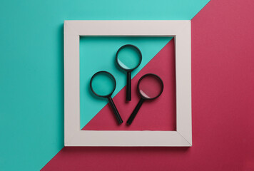 Magnifiers in white frame on pink blue background. Creative layout. Business concept. Minimalism