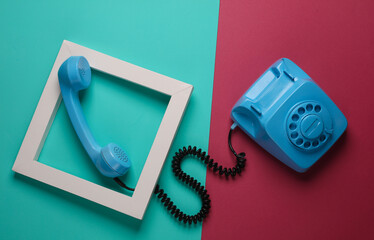Retro rotary telephone in white frame on pink blue background. Creative layout. Minimalism