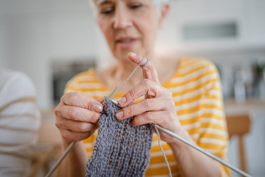 close up on hands of senior caucasian woman needle work knitting - Powered by Adobe
