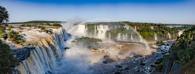 Fototapeta na wymiar Perfect rainbow over Iguazu Waterfalls, one of the new seven natural wonders of the world in all its beauty viewed from the Brazilian side - traveling South America - Panorama