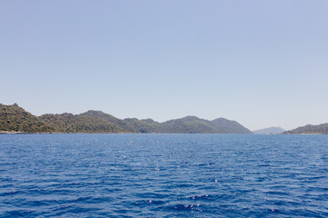 Beautiful seascape on a sunny day In Turkey. The Mediterranean Sea, surrounded by mountains, with picturesque islands on a summer day. Summer background with blue ocean