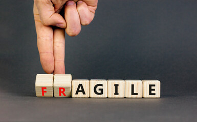 Agile or fragile symbol. Concept words Agile and Fragile on wooden cubes. Beautiful grey table grey...