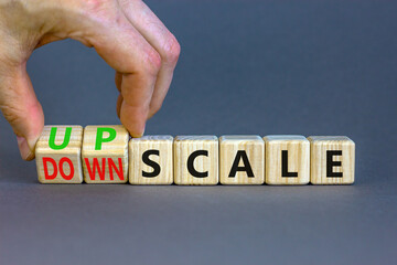 Upscale or downscale symbol. Concept words Upscale or Downscale on wooden cubes. Beautiful grey table grey background. Businessman hand. Business upscale or downscale concept. Copy space.