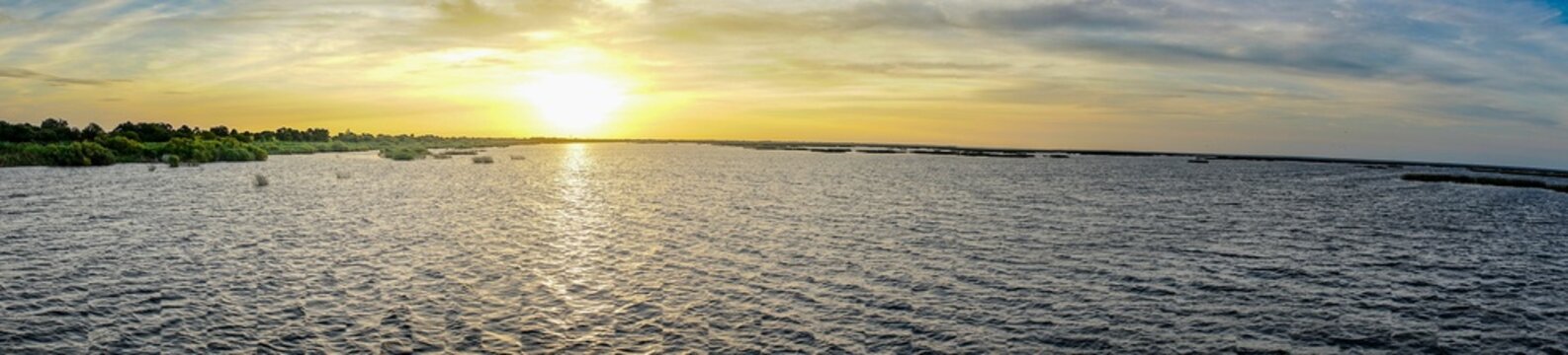 View of Lake Okeechobee surrounded by lush greenery at sunset in Florida, the United States