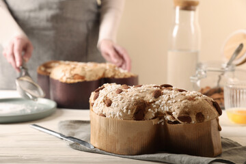 Delicious Italian Easter dove cake (traditional Colomba di Pasqua) on white wooden table, space for text