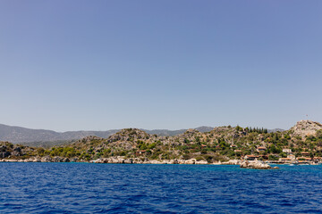 Beautiful view of the Mediterranean Sea with yachts. Picturesque landscape of blue ocean and green mountains on a sunny summer day. The sunken city of Kekova, Türkiye - 28 July 2023