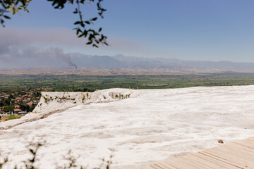 Unreal landscape with white calcium hills and blue ponds in Pamukkale, Turkey. Journey to the old...