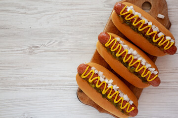 Char Grilled Hot Dog with Mustard, Relish and Onion on a rustic wooden board, top view. Copy space.