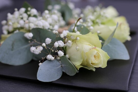 Decorative table arrangement featuring several wedding boutonnieres, accented with vibrant flowers