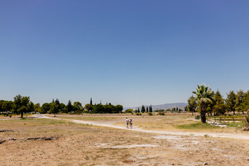 Obraz premium Old dilapidated architecture of Turkey. Ruins of an ancient city. Journey to the old city. Mountain landscape. Ancient city of Hierapolis, Pamukkale, Türkiye - July 29, 2023