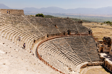 Old dilapidated architecture of Turkey. Ruins of an ancient city with huge amphitheater. Journey to the old city. Mountain landscape. Ancient city of Hierapolis, Pamukkale, Türkiye - July 29, 2023