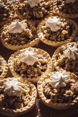 Closeup of an array of miniature pies, topped with a generous dollop of creamy frosting