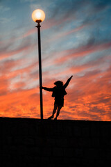 silueta de una chica de rulos, en un atardecer rojizo en la ciudad costera de Mar del plata