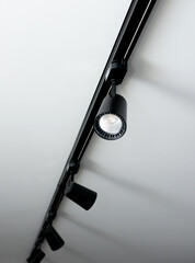 Led track lamp on the ceiling in the interior. Interior spotlight in black color. Modern track lamp with many rotary lamps