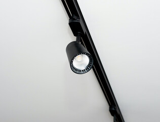 Background Led track lamp on the ceiling in the interior. Interior spotlight in black color. Modern track lamp with a lot of swivel lamps. The concept of lighting in the house.
