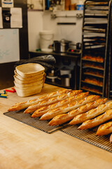 Freshly baked golden crusty baguettes lined up on bakers tray fresh from the oven in professional kitchen