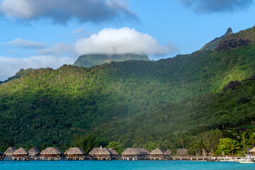 Paysage de la plage de Tema'e à Moorea en Polynésie, avec ses bngalows sr pilotis et le mont Tohiea