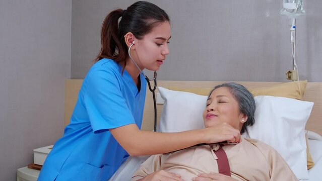Specialist doctor woman checkup with patient elderly with stethoscope for listening heartbeat in hospital ward, medical and sick, nurse diagnostic patient with sick, insurance and health concept.