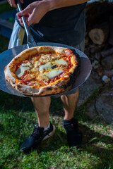 person holding pizza, homemade in the wood burning pizza oven , Margherita 