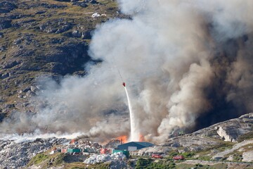 Helicopter dropping water on a fire in Qaqortoq, Greenland