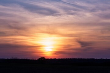 Fototapeta na wymiar Beautiful sunrise over the silhouette of a field.