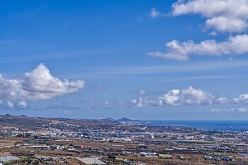 Obraz premium Aerial view of a city on the coast against the blue sea on a sunny day
